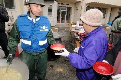 暖かい豚汁を振る舞う自衛隊員