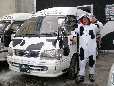 牛柄のタクシーと着ぐるみ姿の運転手