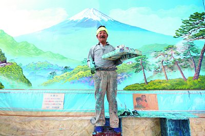 描き上げた富士山を背に笑顔の中島盛夫氏