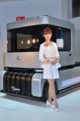 ダイハツが開発進める次世代燃料電池車の前で微笑む美女