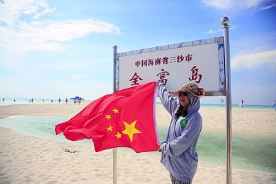 嬉々として五星紅旗を掲げる中国人観光客