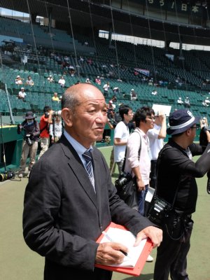 グラウンドで取材をする小野塚康之さん