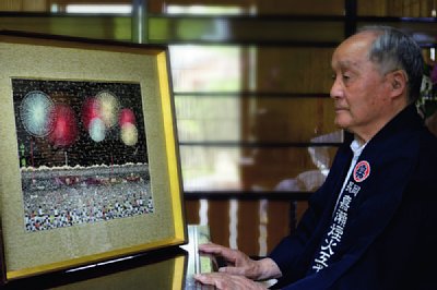 山下清の貼絵『長岡の花火』を見入る嘉瀬誠次氏