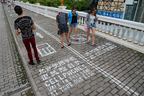 「スマホ禁止」レーンの上を堂々とスマホを使いながら歩いて行く中国人たち