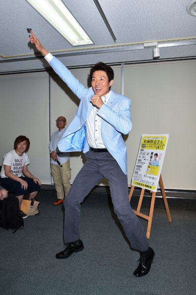 元気に右腕を上げる松岡修造