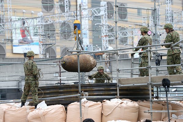 クレーンで搬出される不発弾