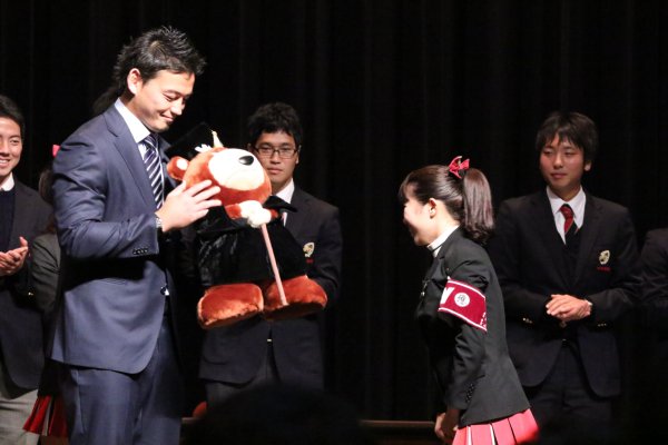 学生に熊のぬいぐるみをプレゼントされる五郎丸歩選手