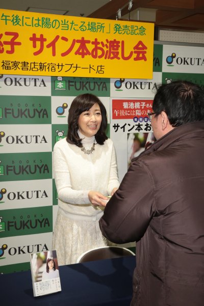 ファンにサイン本を手渡す菊池桃子