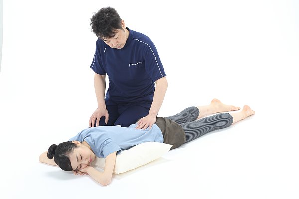 仙骨の上に手を置き、手のひらの温かさを伝える気持ちでお尻を左右水平にゆっくりゆらす