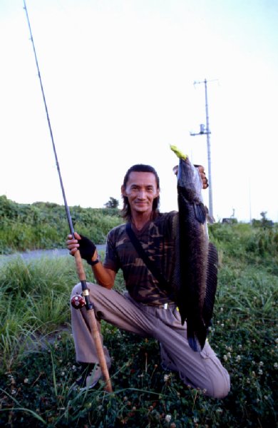 2000年頃、青森～新潟の釣行にて雷魚を釣った楠ノ瀬直樹氏。（撮影：広中秀俊氏）