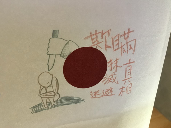 日章旗を模したカードに苛烈な批判が書き込まれ、壁に貼られていた