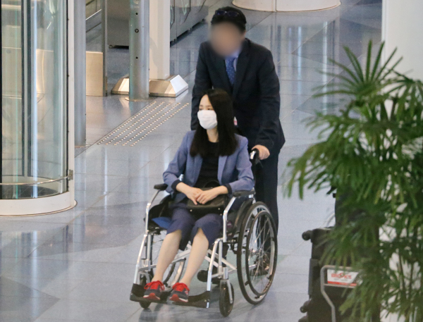 羽田空港では夫が聖子の車椅子を押していた