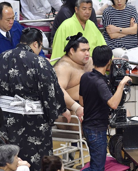 車椅子で花道を引き揚げる高安（写真：共同通信社）