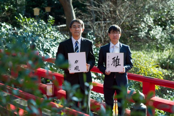 揮毫した色紙を手に。羽生氏は「玲瓏」、井山氏は「志」と書いた