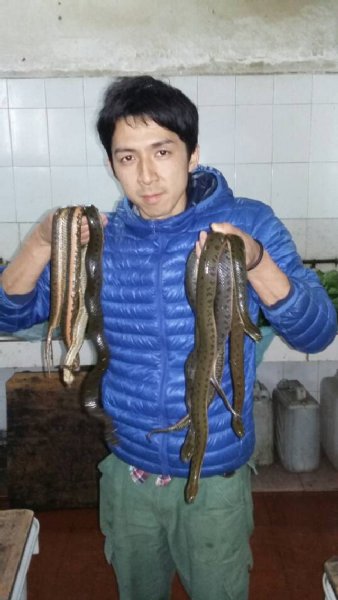 ヘビ料理店でこれからさばくヘビを持つ西谷氏