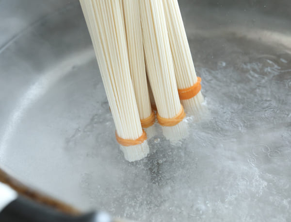 麺の先端を輪ゴムで結び、結び目からゆでる