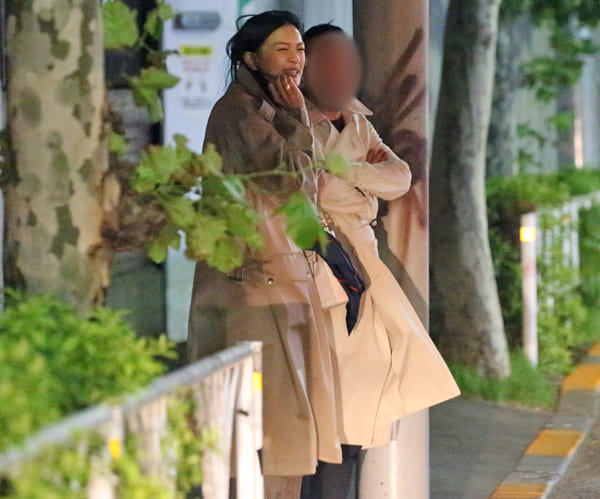 気温が下がり始めた秋の夜、寒そうにタクシーを待つ栄倉