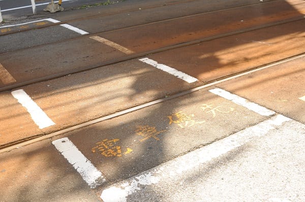 ミニ踏切の路面に書かれた“電車優先”の文字