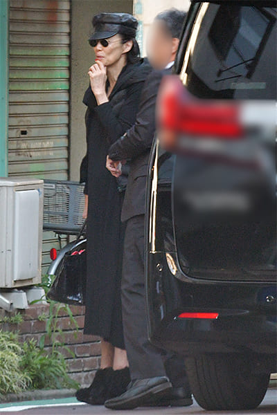 全身黒の服に黒いサングラス姿で