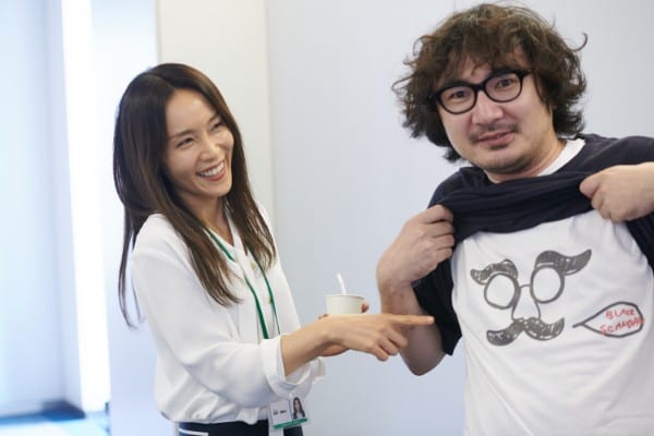 スタッフTシャツを指差し破顔一笑
