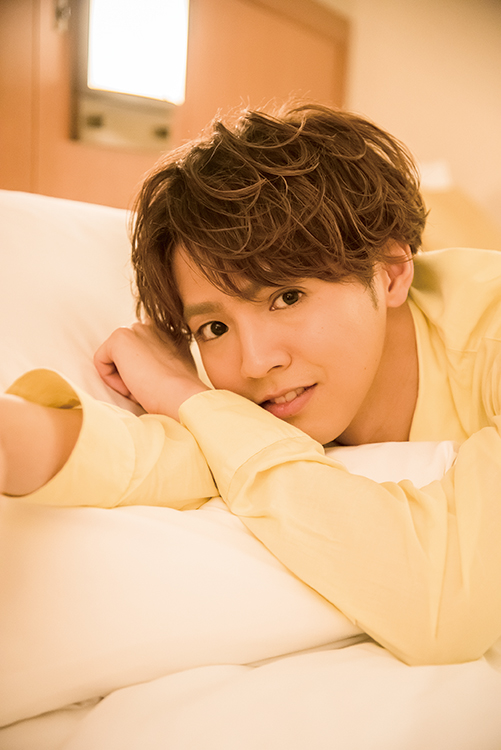 ベッドに寝転び見つめる片寄（撮影／川野結李歌）