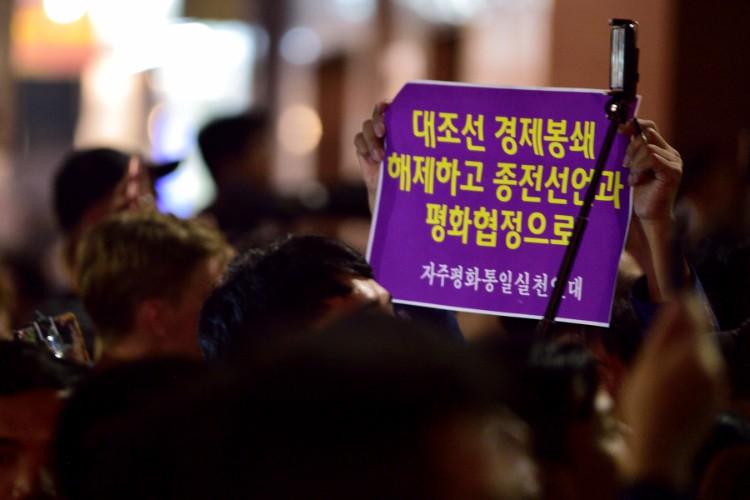 会談場所のメトロポールの人垣の中で紙幕を掲げる韓国人（2月27日、筆者撮影）