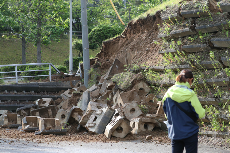 地震の影響で崩落した駐車場ののり面（新潟県村上市。時事通信フォト）