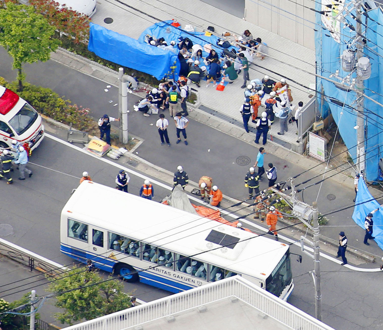 川崎の児童殺傷事件の現場近くで手当てを受ける人たち（共同通信社）