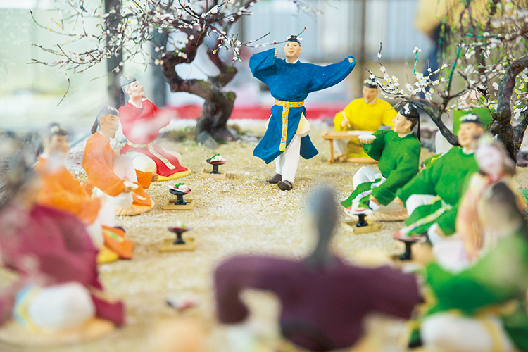 『太宰府政庁跡』に隣接する『太宰府展示館』には、令和の由来となった梅花の宴を再現した博多人形のジオラマが