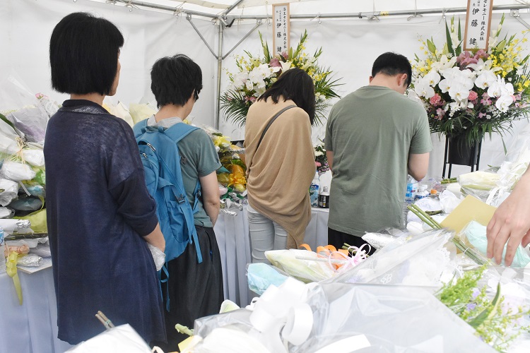 アニメ制作会社「京都アニメーション」近くに新たに設置された献花台で手を合わせる人々（時事通信フォト）