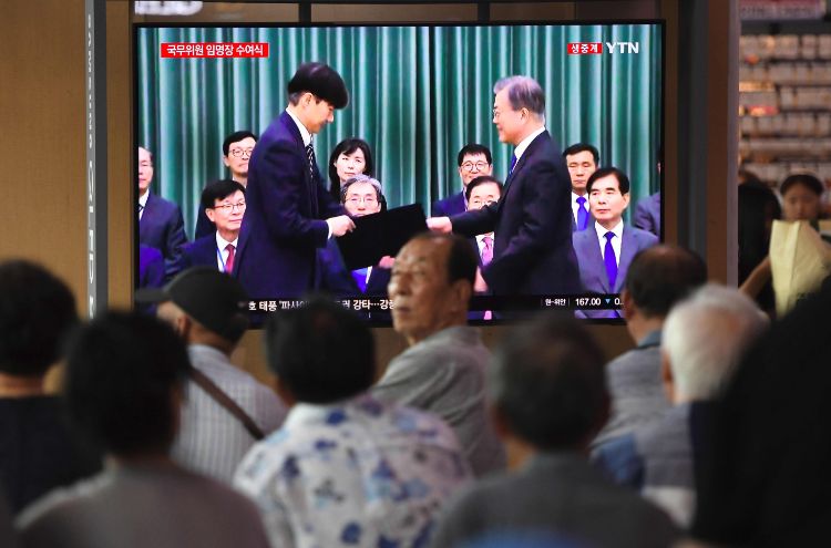 新法務大臣の任命の様子をテレビで見守るソウル市民（AFP=時事）