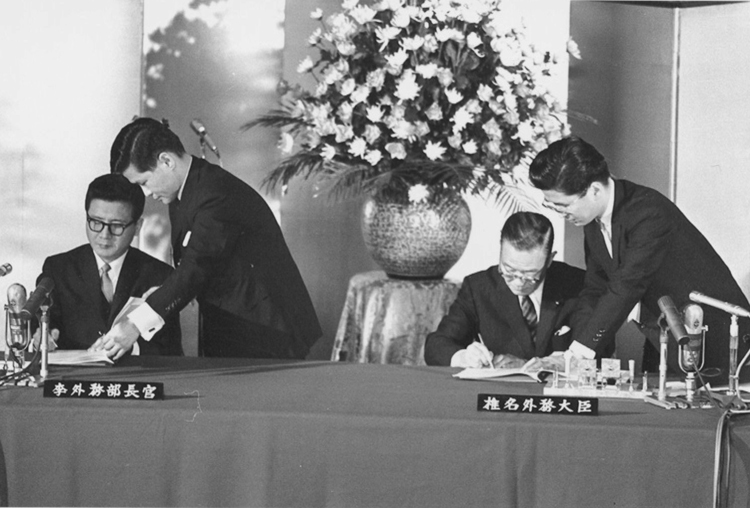 日韓基本条約に調印する李東元韓国外相（左）と椎名悦三郎外相。1965年（共同通信社）