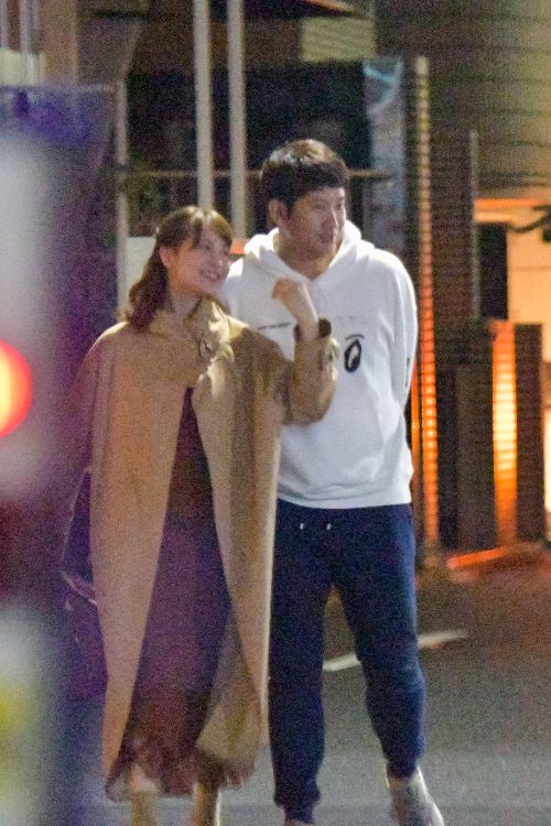 笑顔で夜の街を歩く菅野智之と野崎萌香