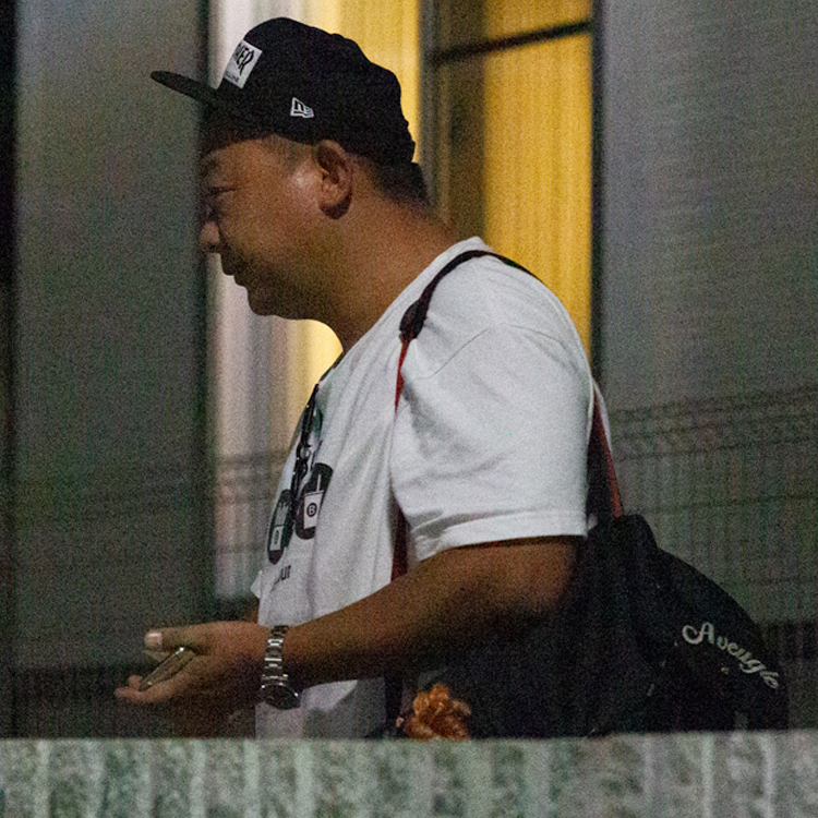 白Tシャツ姿で記者の質問に答える木下