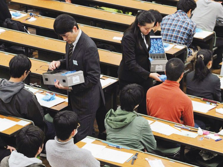 大学入試センター試験で、受験生にリスニング用の機器を配布（写真／共同通信社）