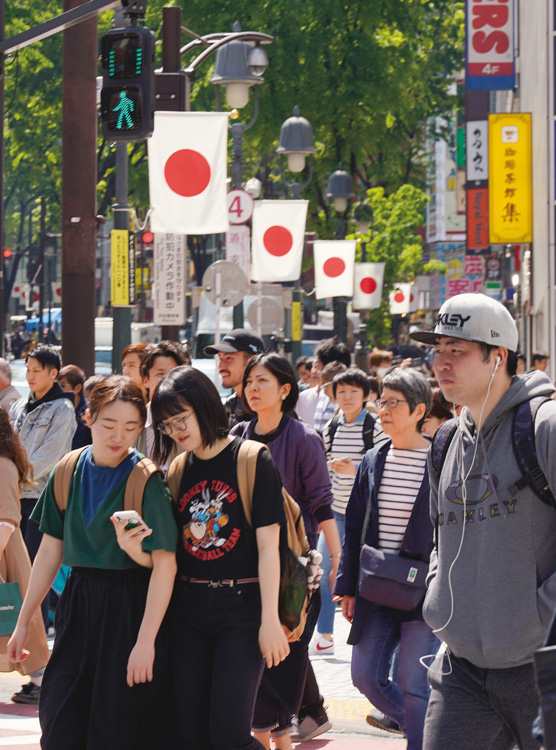 日の丸が掲げられた渋谷の道玄坂交差点周辺（時事通信フォト）