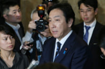 安倍晋三首相に辞表提出後、記者団の質問に答える菅原一秀経済産業相(中央)=25日、国会内