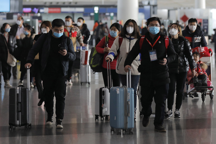 北京国際空港でマスクを着用して歩く乗客（EPA＝時事通信フォト）