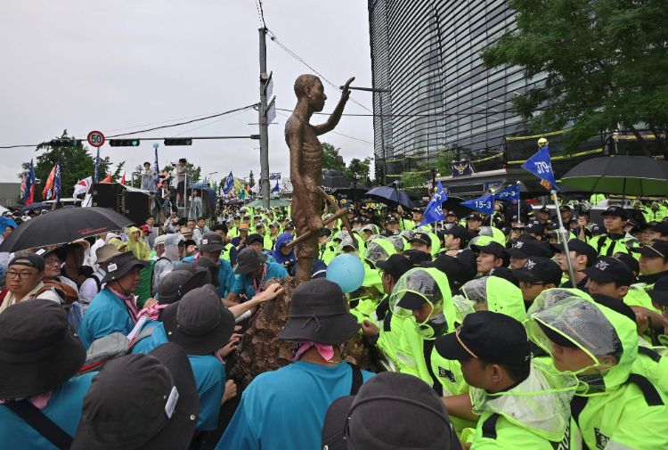 「徴用工像」をソウルの日本大使館に向けて動かす反日デモ参加者たち（AFP＝時事）