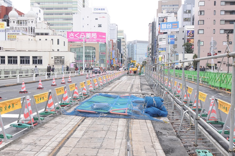 第二次世界大戦中に廃止された都電の線路と敷石がアスファルトの下から出てきた