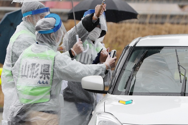 山形県では県境を越えて移動する人たちへの検温を開始した。山形自動車道の山形蔵王パーキングエリアで検温を行う山形県の職員（時事通信フォト）