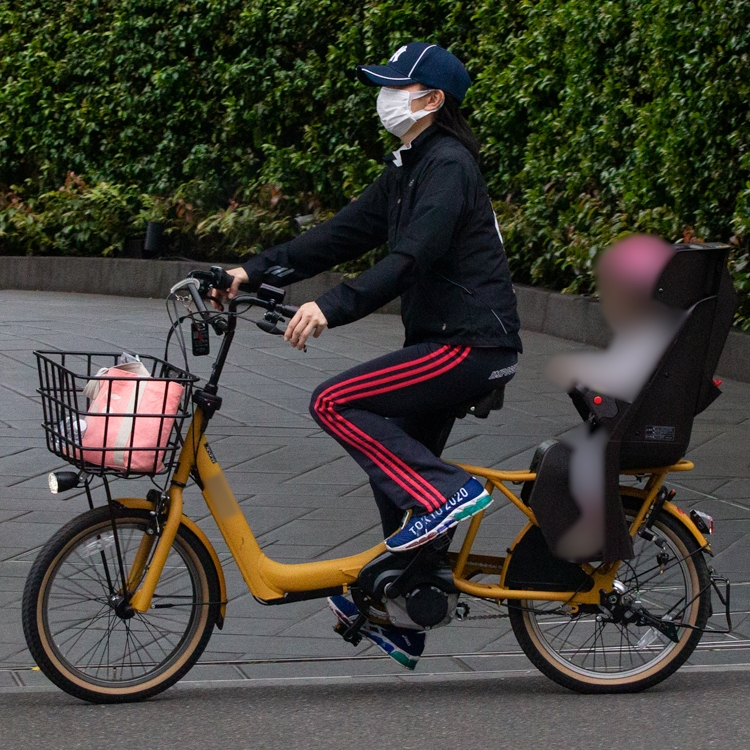 子供を乗せて自転車をこぐ東尾