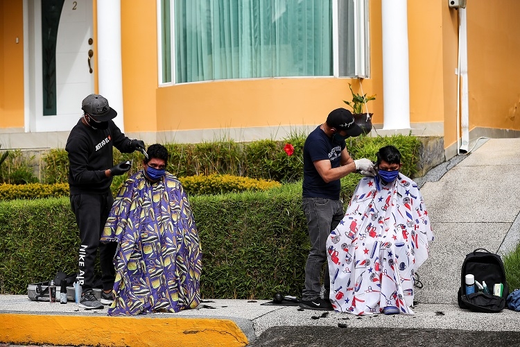 エクアドルではコロナ対策で理容師たちは屋外で客の散髪（EPA＝時事）