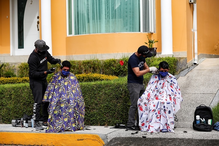 エクアドルではコロナ対策で理容師たちは屋外で客の散髪（EPA＝時事）