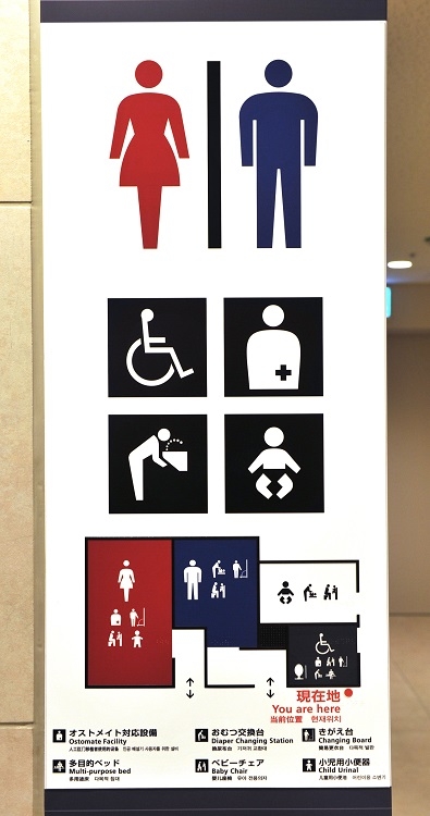 法整備とともに公共施設では多目的トイレの設置がすすんだ。多言語対応もしている羽田空港の案内標識（時事通信フォト）