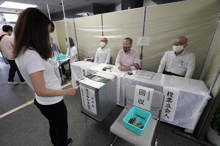 新型コロナウイルスの感染防止のため、立会人席にビニールシートを張られた東京都知事選の期日前投票所（時事通信フォト）