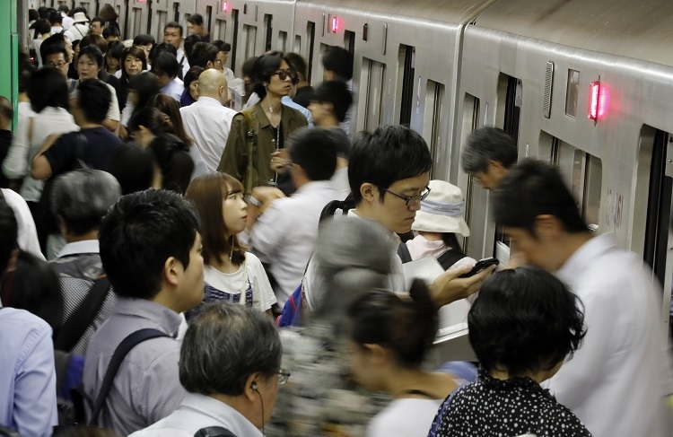 午前8時台の通勤ラッシュで混む都営大江戸線の新宿西口駅のホーム（時事通信フォト）