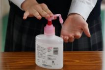 新型コロナウイルス感染予防のため、登校時に手を消毒する生徒(時事通信フォト)