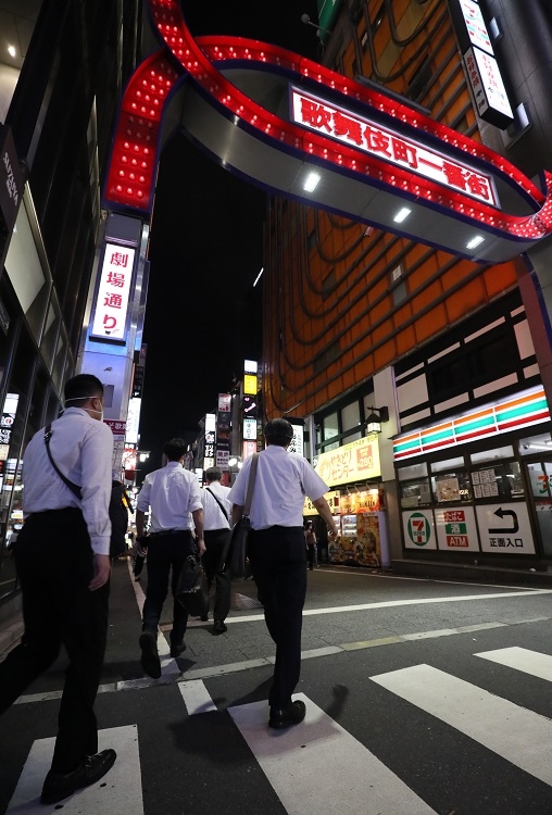 風営法に基づく警視庁の立ち入りと合同で、新型コロナウイルス感染防止対策の周知のため歌舞伎町の店舗に向かう東京都の職員ら。7月24日（時事通信フォト）