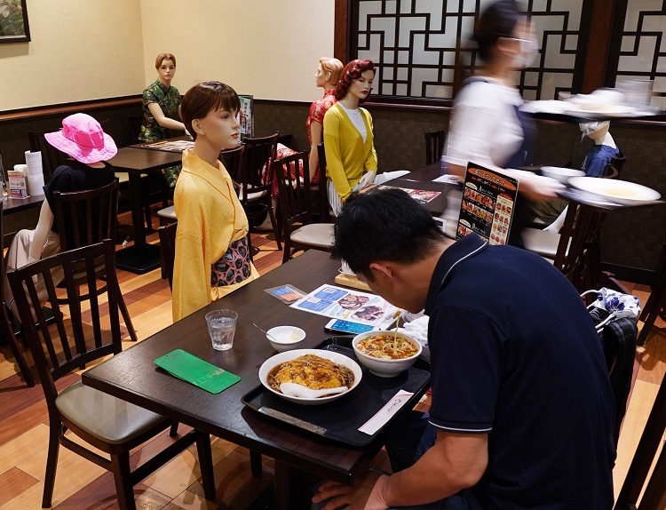 新型コロナウイルス対策で他人との距離を置くため、テーブルにマネキンを配置する東京都北区の中華料理店（時事通信フォト）